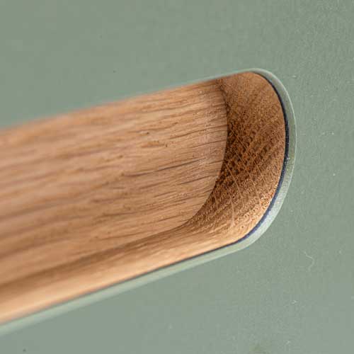 Grebet er lagt i spånpladen, hvorefter der er fræset ud til grebet. Her ses et R15-greb med en behagelig, blød og organisk form. Grebet kan monteres på alle 22 mm fronttyper i finér, laminat og linoleum.